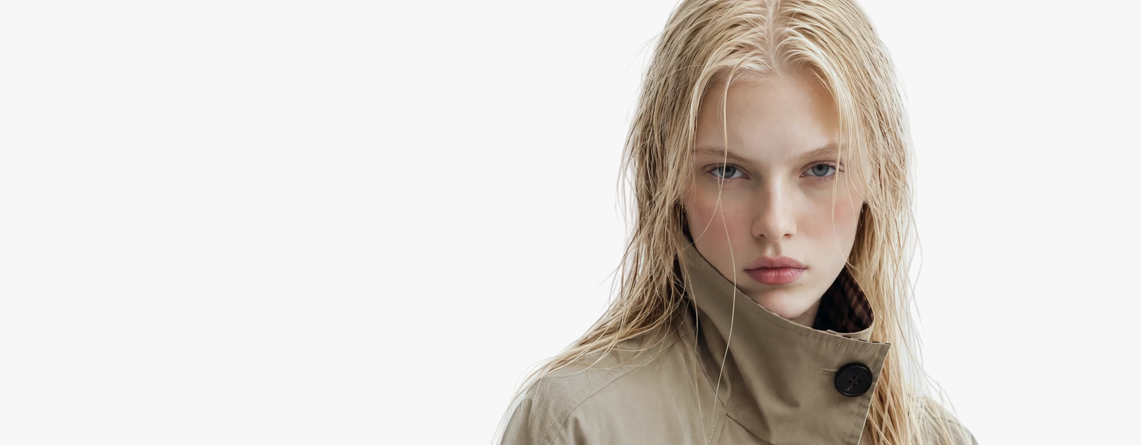 AI generated model with wet blonde hair in a beige trench coat against a pale studio background