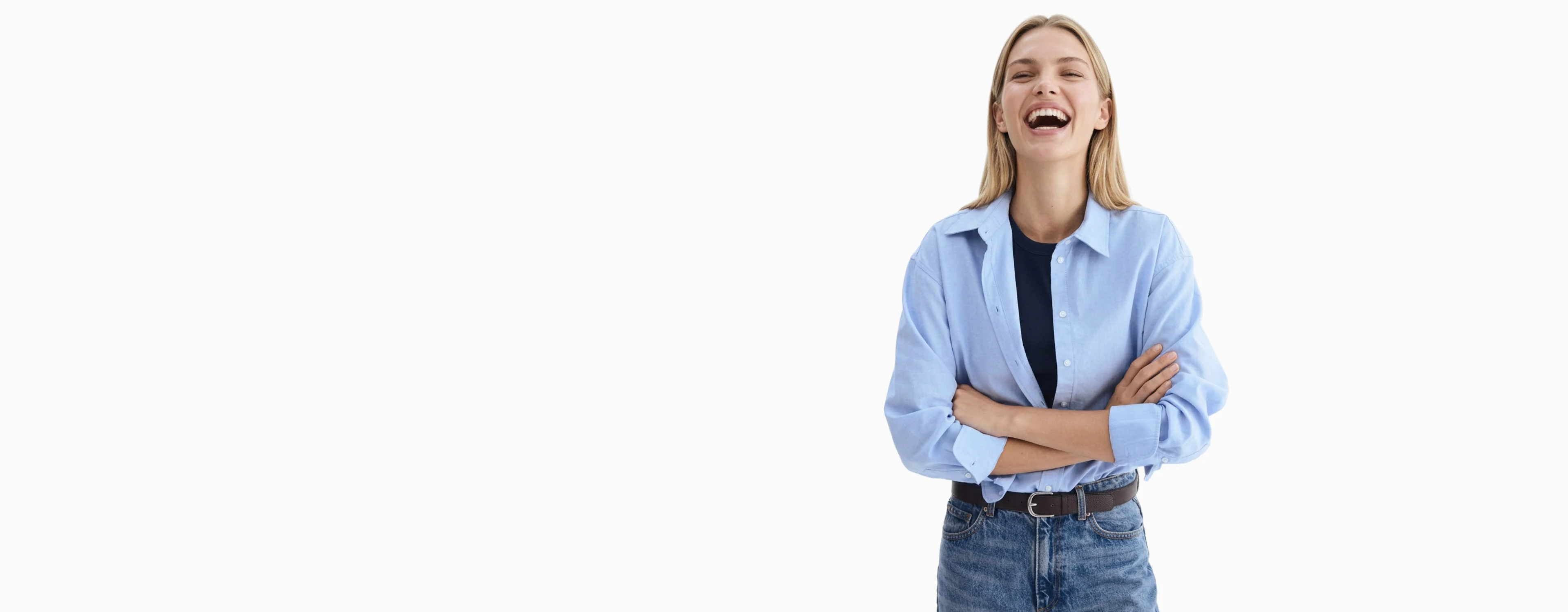 AI generated model laughing in a light blue shirt and jeans against a pale studio background