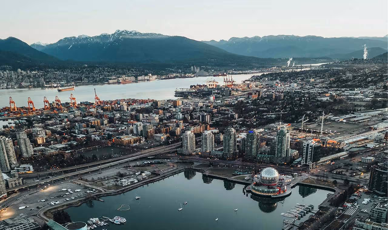 Aerial view of Vancouver with waterfront, buildings, and mountains in the background