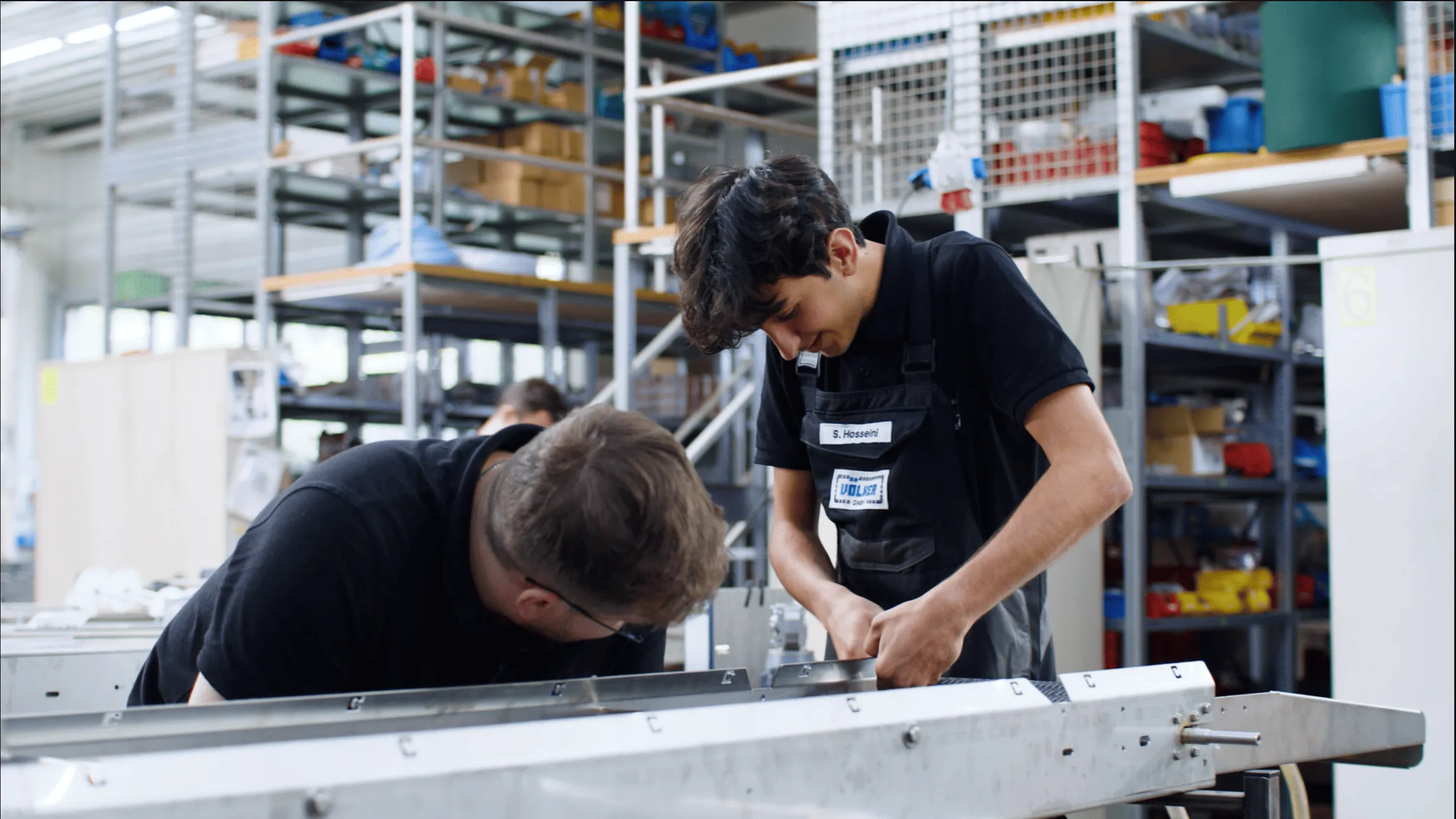 Zwei Mitarbeiter arbeiten an einer Maschine.