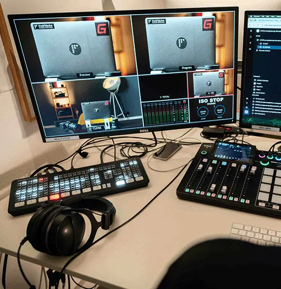Professional video production control room with livestream monitoring screens, audio mixer, and control panel