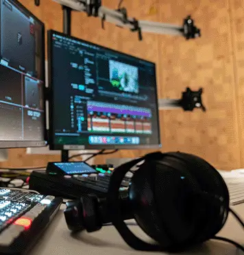 Video editing and livestream production setup with monitor, console, and headphones