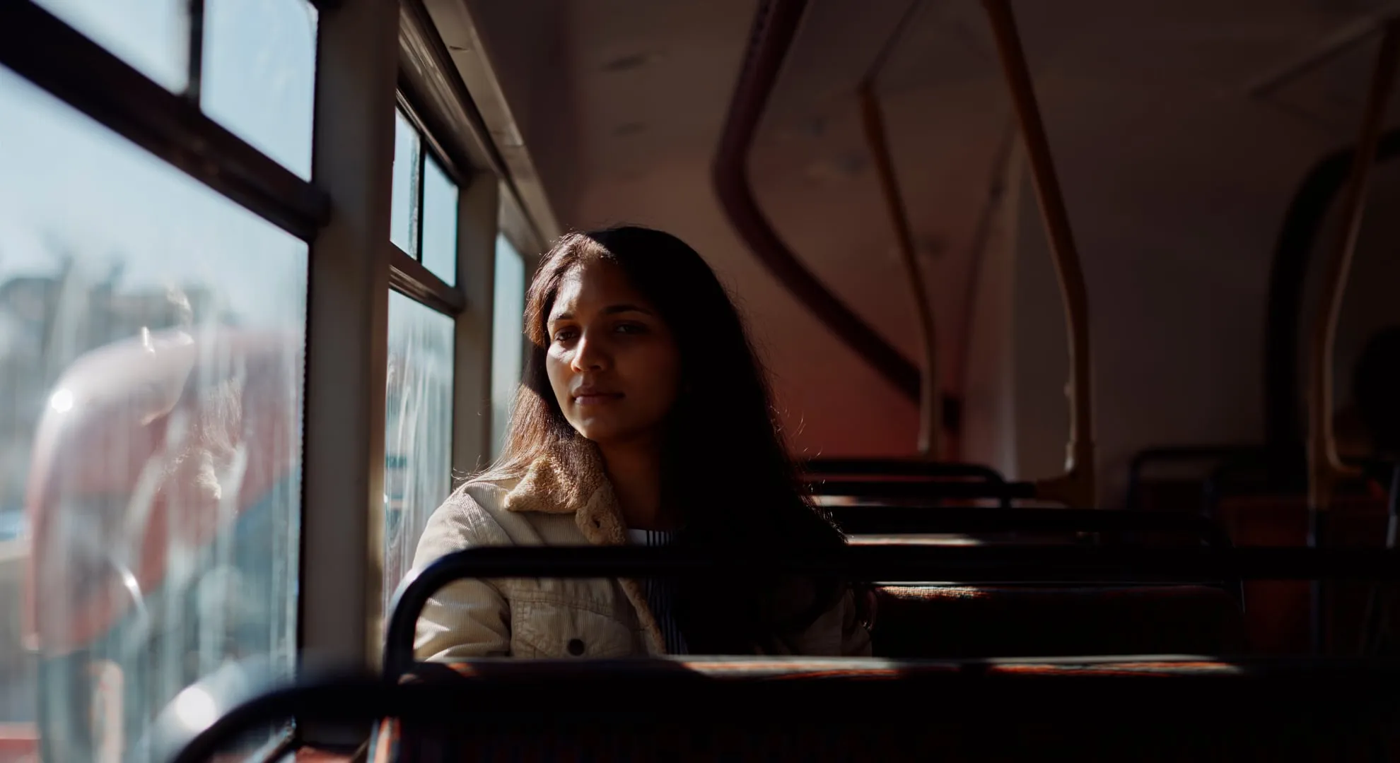 Girl sitting looking out the window of the bus