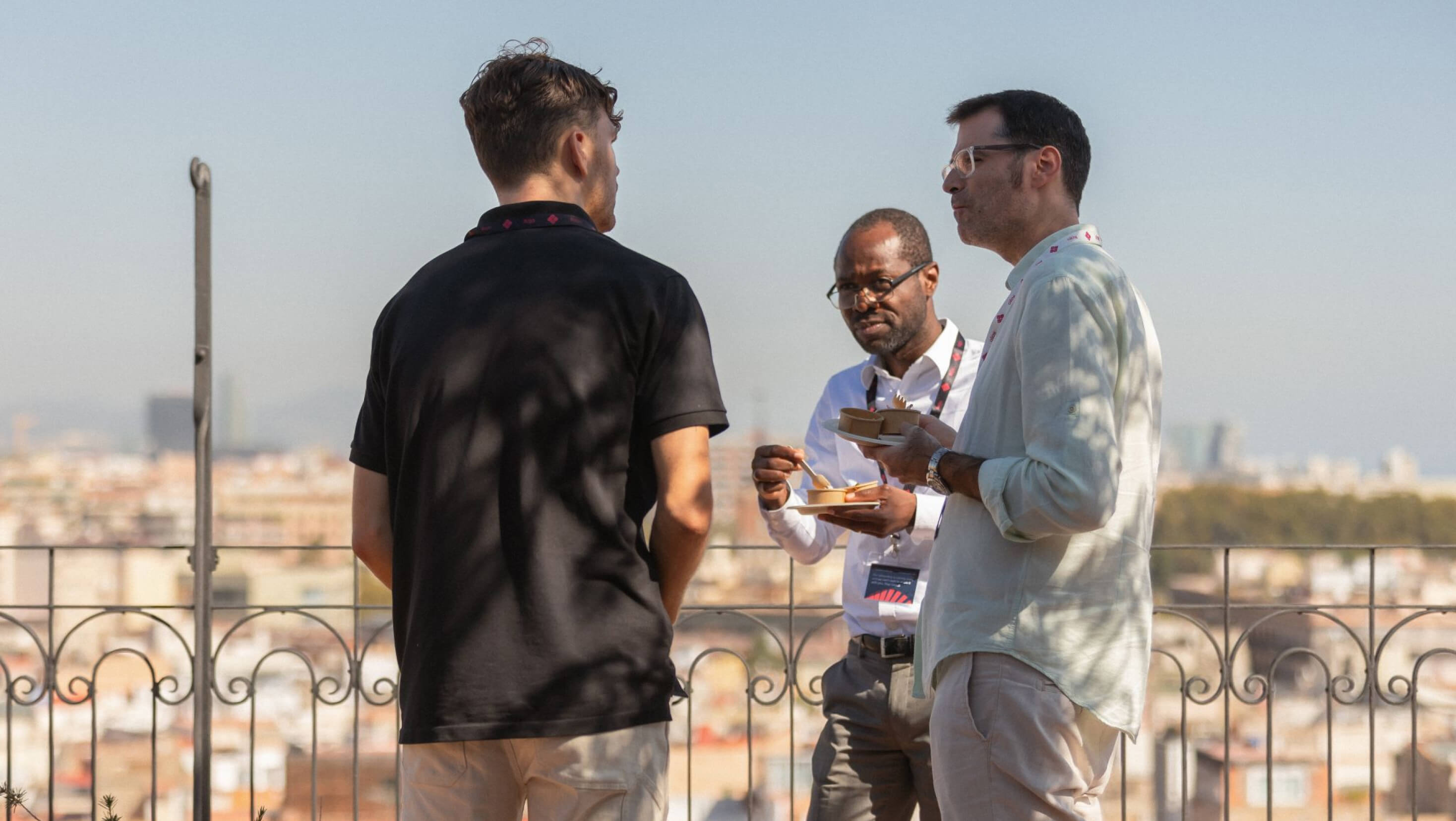 Drie collega's van Rojo in gesprek met elkaar in het zonnige Barcelona.