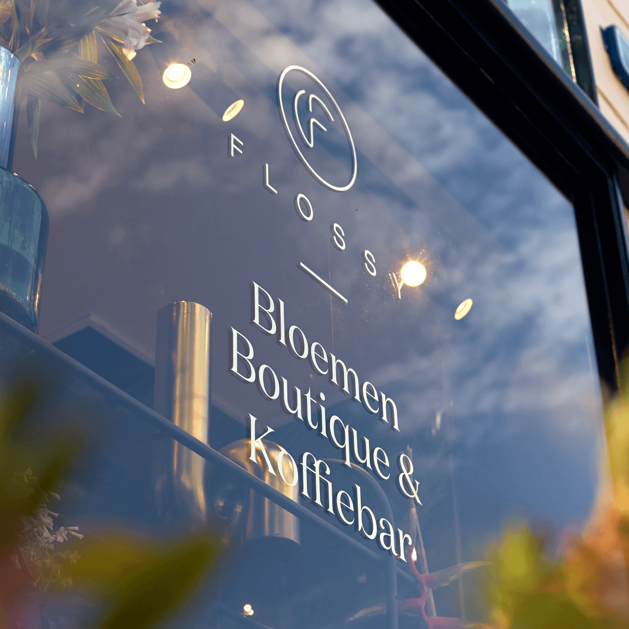 Het logo van Flossy als raam bestickering.