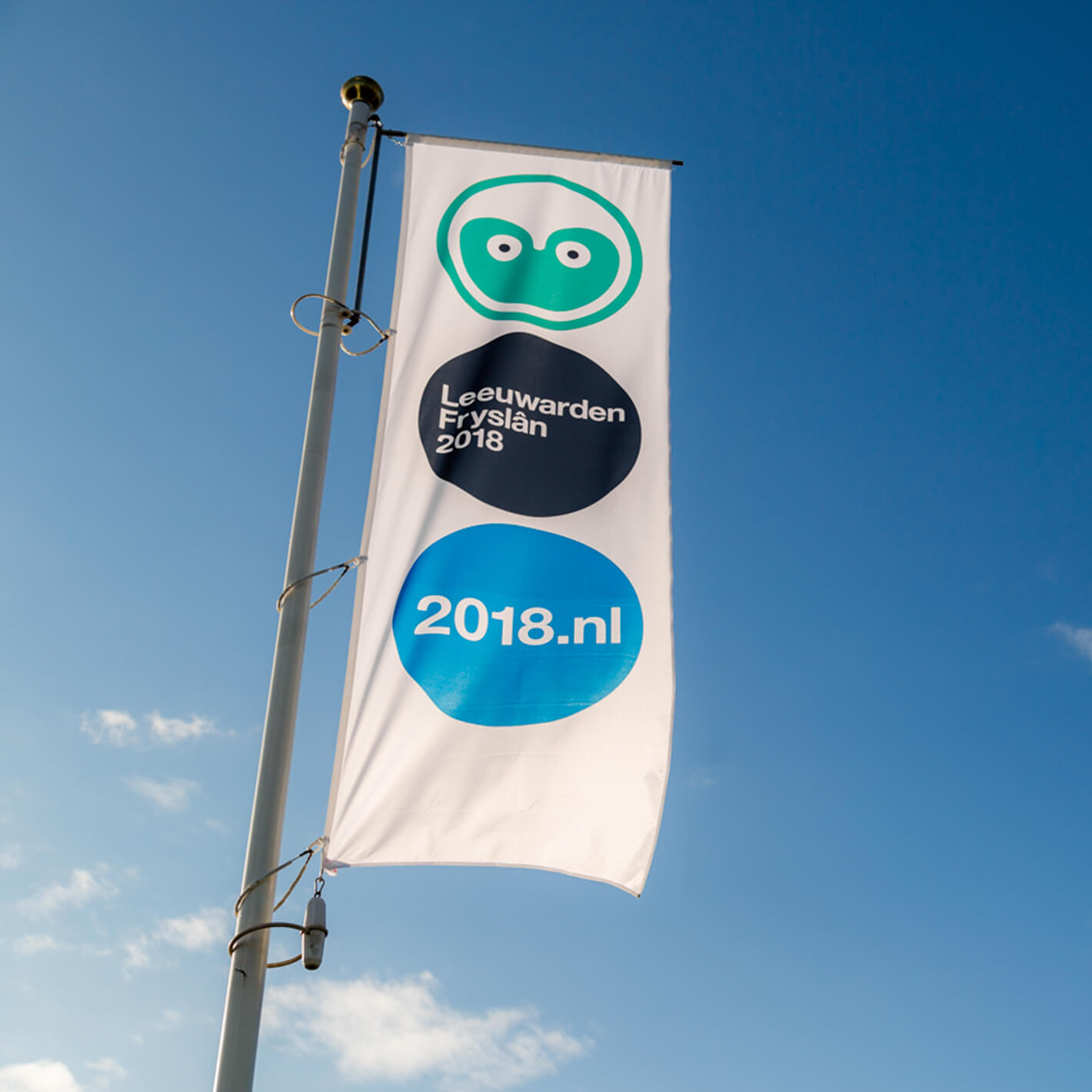 Een vlag met het logo van Leeuwarden-Fryslân Culturele Hoofdstad ontworpen door Studio Piraat.