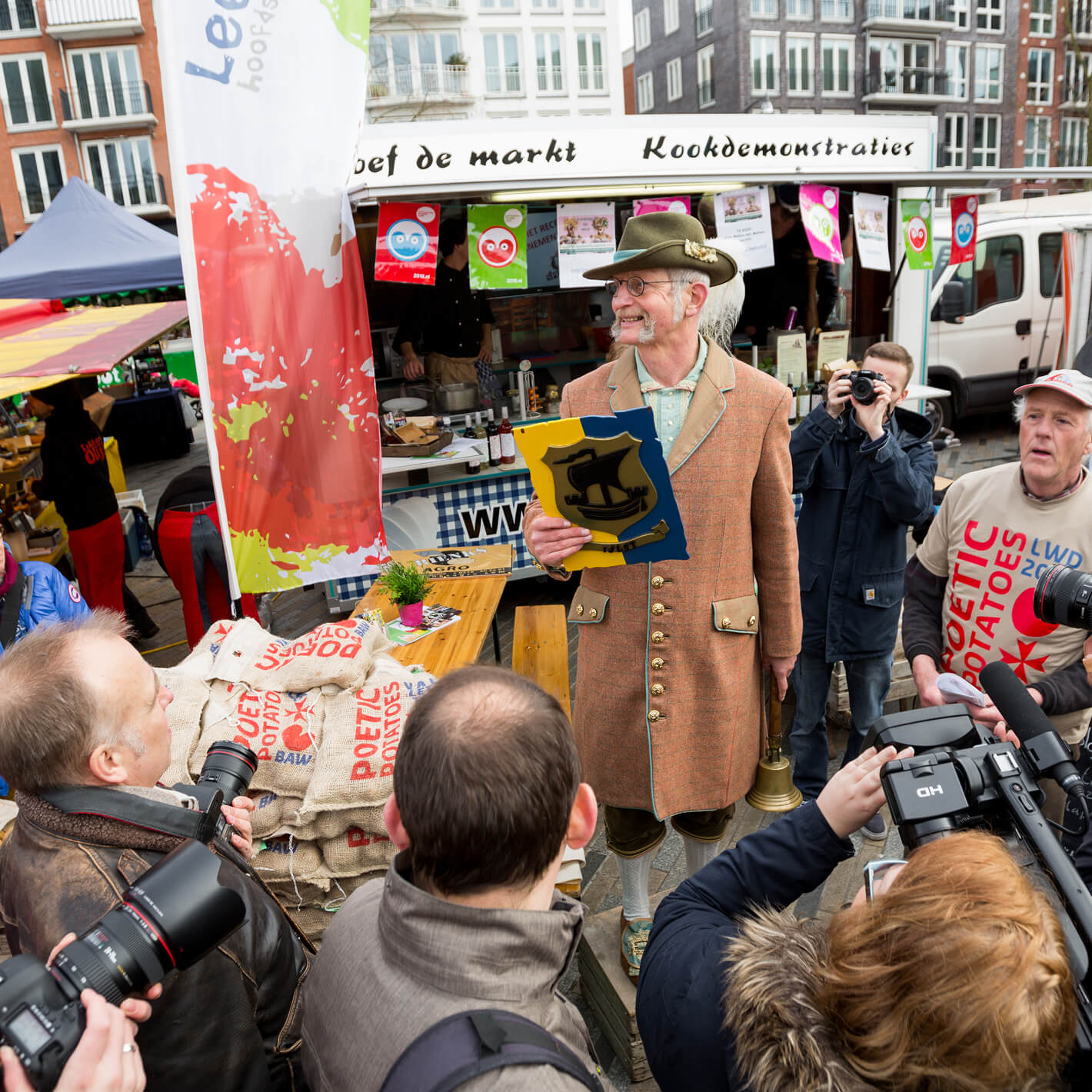 Een foto van de markt met op de achtegrond het logo van Leeuwarden-Fryslân Culturele Hoofdstad ontworpen door Studio Piraat.
