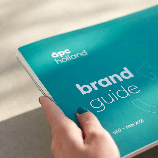 Een foto van het huisstijlhandboek van apc holland ontworpen door Studio Piraat.
