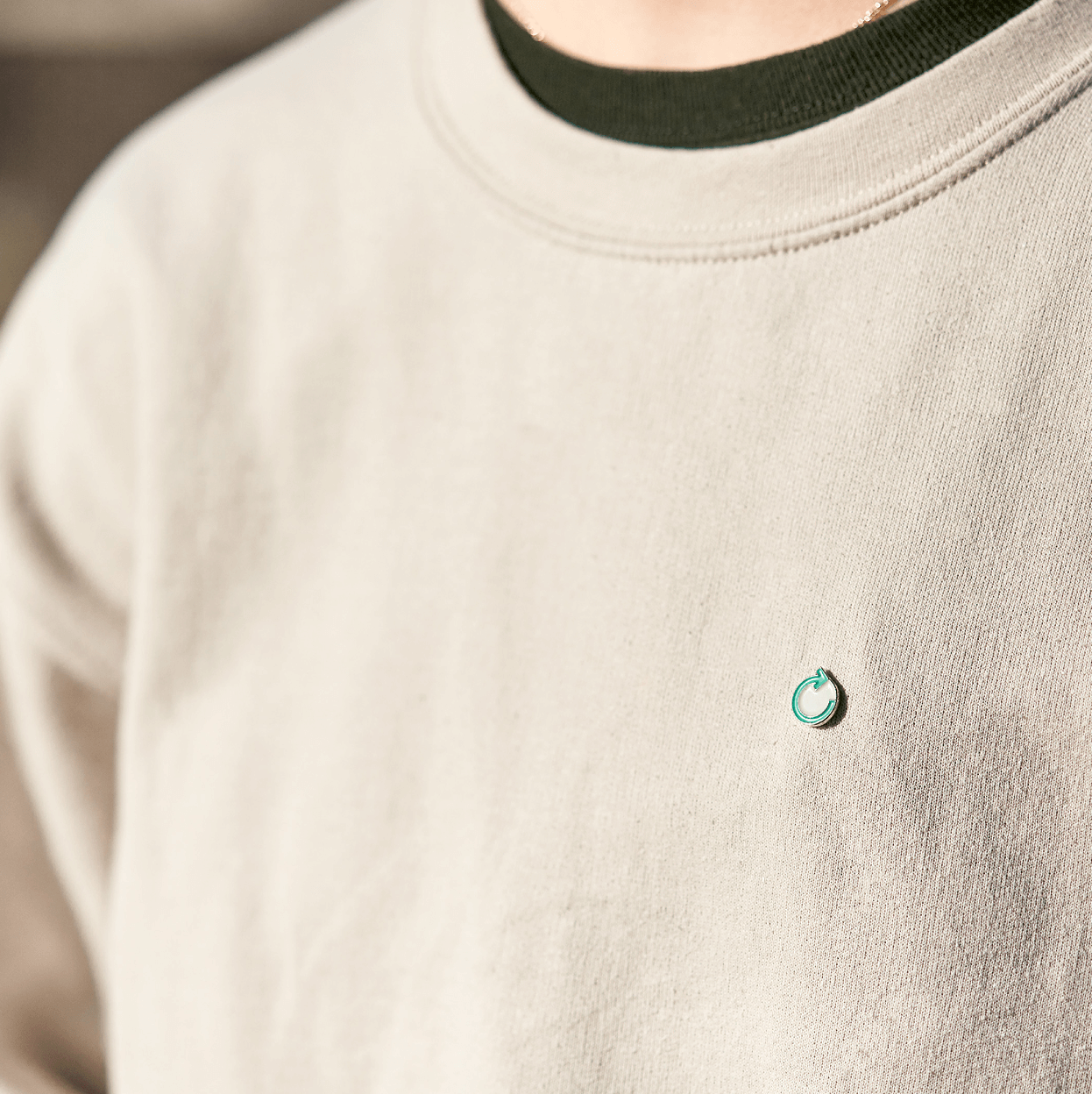 Een foto van de pin met het logo van apc holland ontworpen door Studio Piraat.