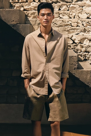 A male Asian fashion model made by Botika named Noah wearing a matching tan short sleeve button down shirt and shorts. 