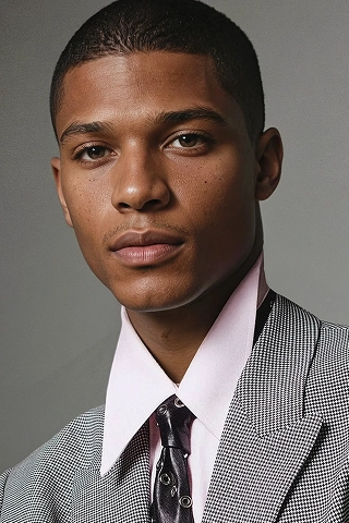 Headshot of a Botika male AI fashion model, Michael, wearing an houndstooth suit. 