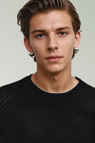 Headshot of Liam, an AI fashion model Botika created wearing a cable knit black sweater. 