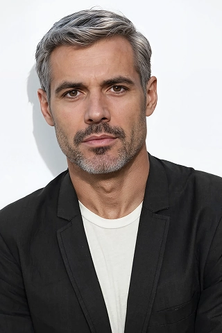 Headshot of a Botika male AI fashion model, Leo. He is wearing a black suit jacket and white tshirt. 