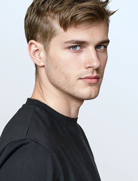 A close up image of Botika's male AI fashion model Bran, wearing a black tshirt in a side profile shot. 