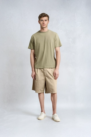Bran, a Botika male AI fashion model wearing a dark tan tshirt and tan shorts. 