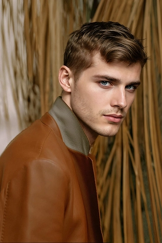 Headshot of Botika's male AI fashion model Bran. He is wearing a brown leather jacket in a side profile shot. 