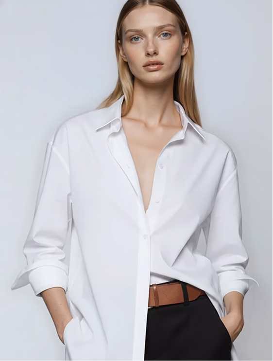 Product shot of a blonde female AI fashion model wearing a white button down shirt tucked into dark dress skirt. 