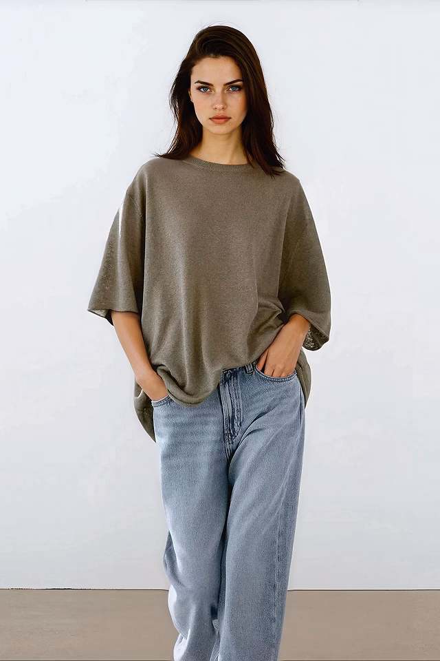Aurora, a Botika AI fashion model wearing an oversized green tshirt and jeans.