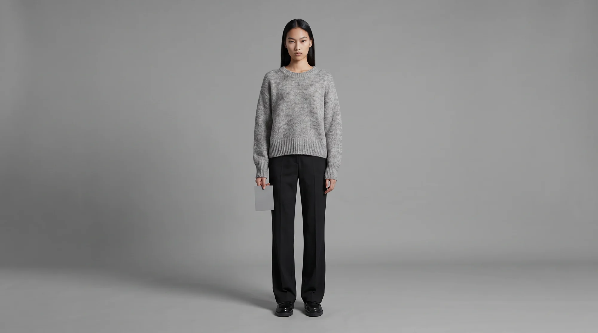 Model standing square to camera on a plain grey backdrop under flat even reference lighting