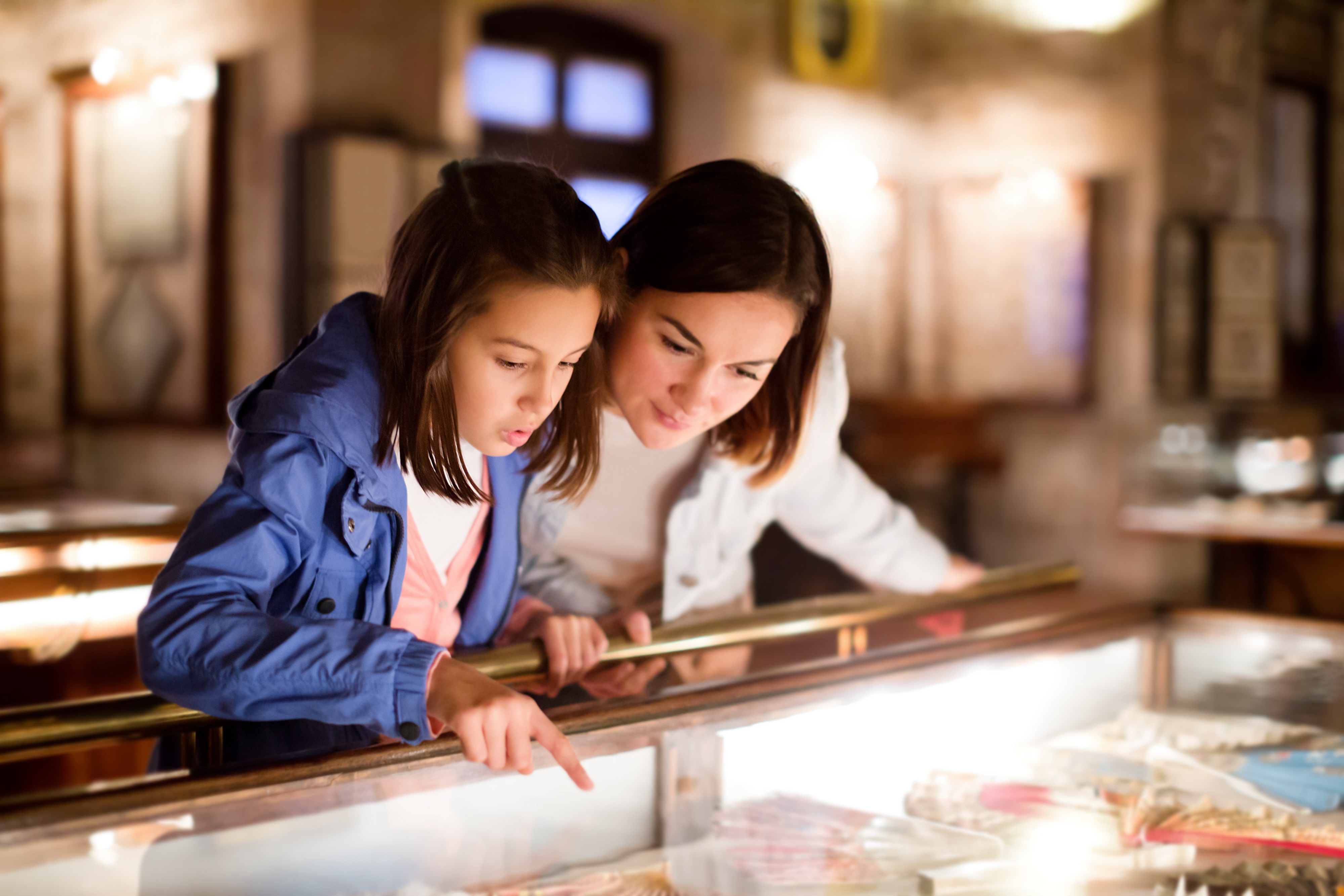 A woman and a young girl looking at an exhibit in a museum, representing the educational and cultural attractions near Paloma Luxury Apartments in San Antonio, TX.