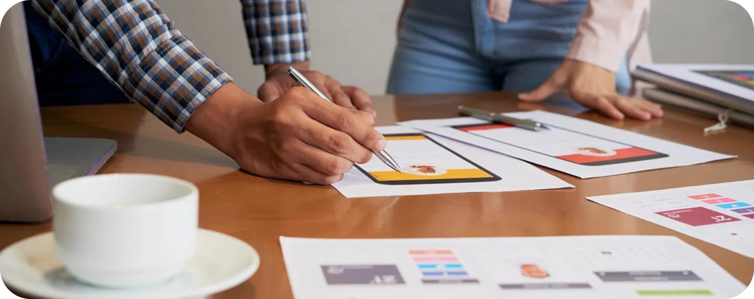 Design team creating mobile app UI/UX wireframes and interface layouts for digital product development.