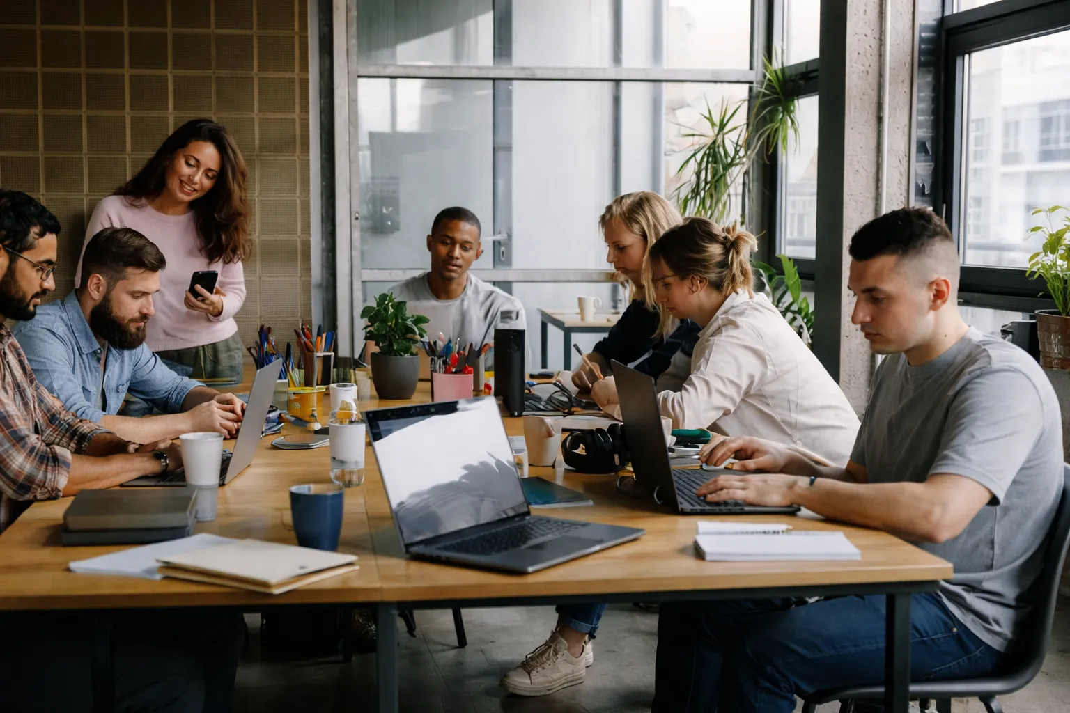Product team collaborating on laptops in a modern workspace developing software and digital solutions