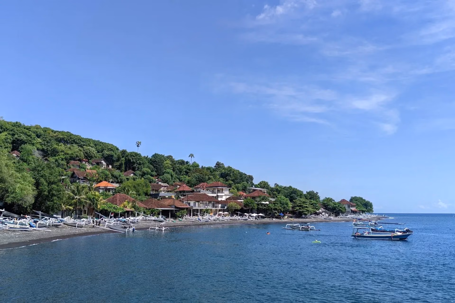 Jemeluk Beach surrounded with lush green hills.