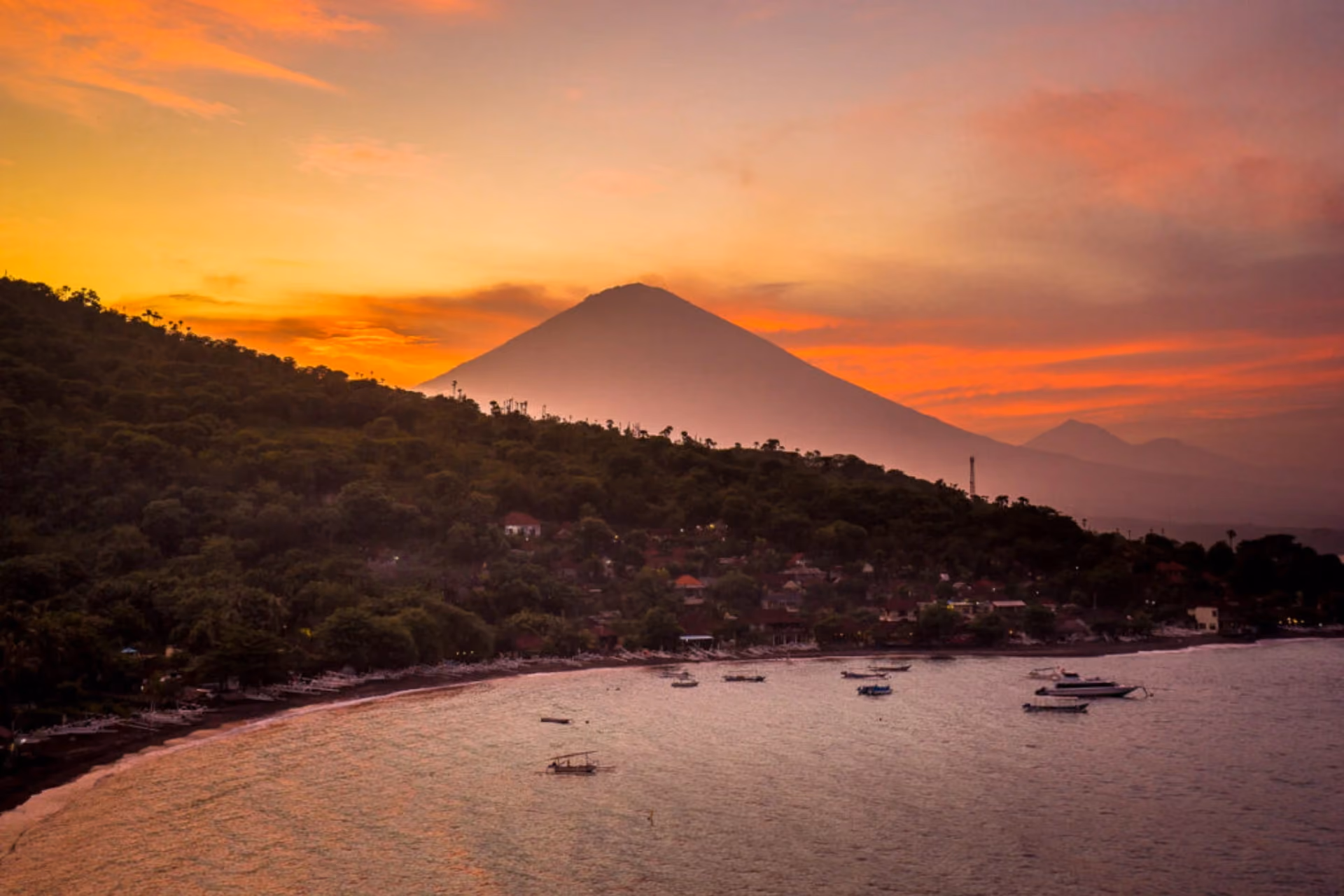 Scenic view from Sunset Point in Amed, Bali, featuring a golden sunset over the ocean.