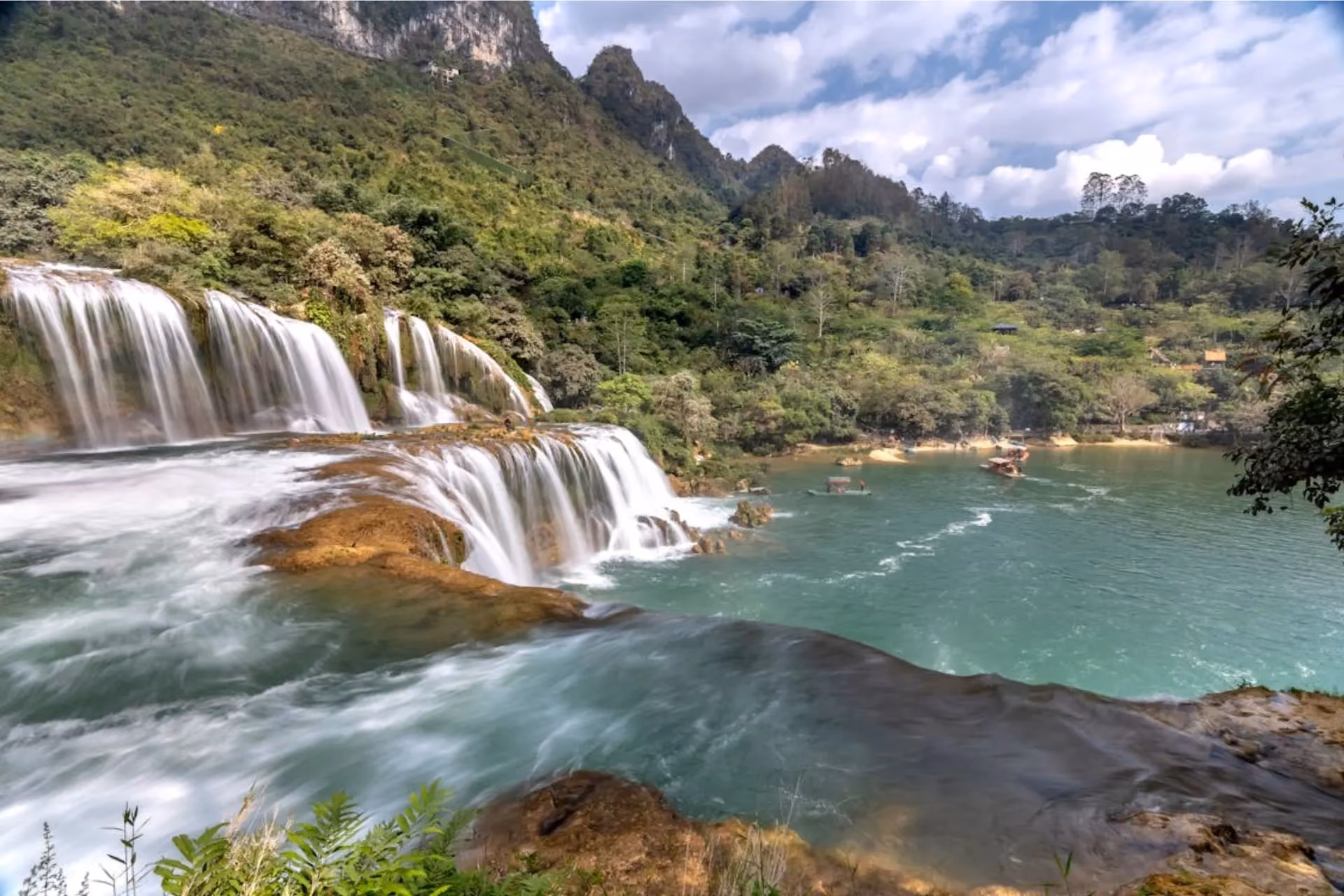 Ban Gioc Waterfall is famous for its wide, multi-tiered falls surrounded by green mountains