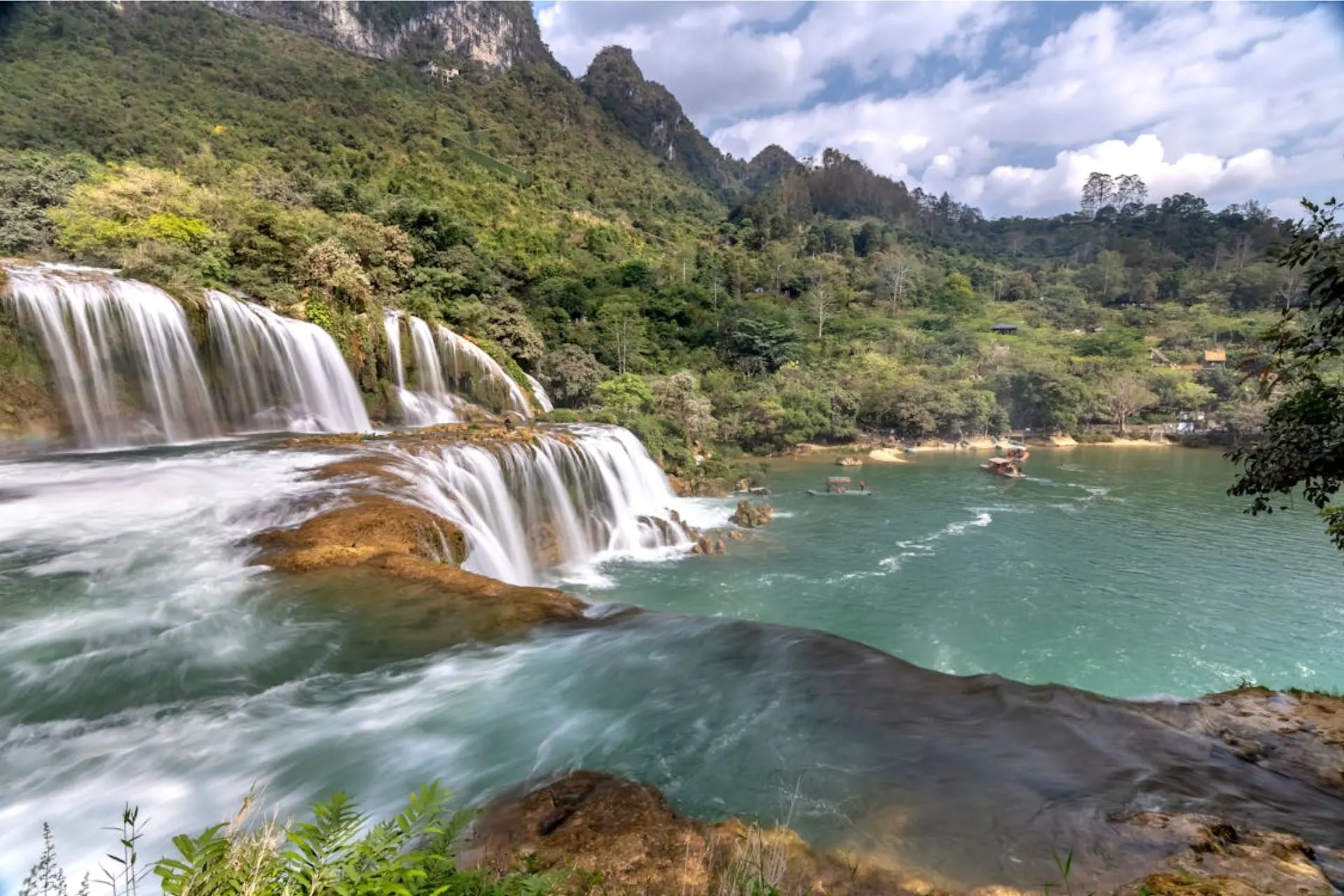 Ban Gioc Waterfall is famous for its wide, multi-tiered falls surrounded by green mountains