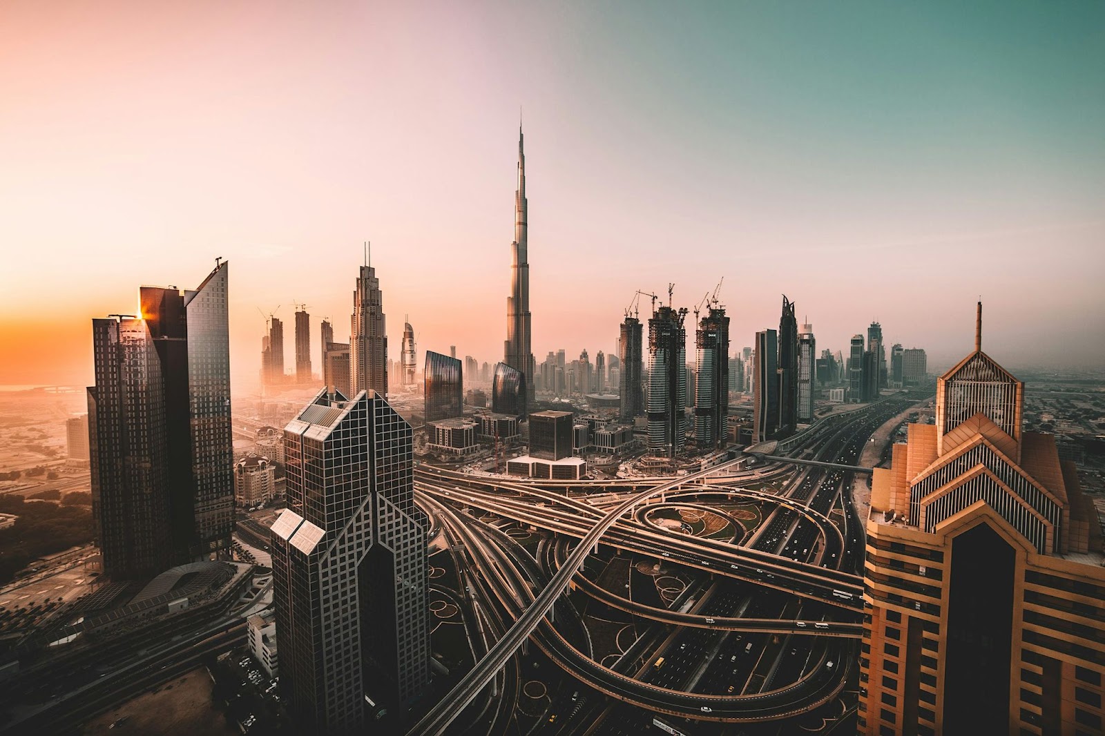 Dubai skyline with modern skyscrapers and the Burj Khalifa at sunset.‍