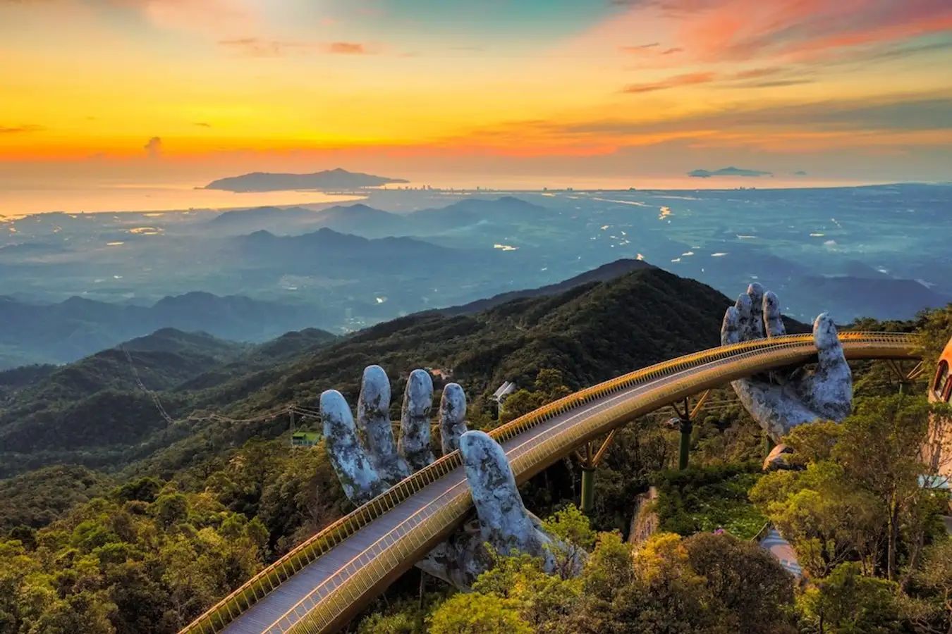 view of the Golden Bridge held by giant stone hands in Ba Na Hills, Da Nang, Vietnam 