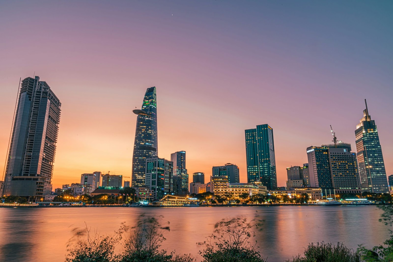 Ho Chi Minh City skyline at dusk with modern high-rise buildings reflecting on the Saigon River