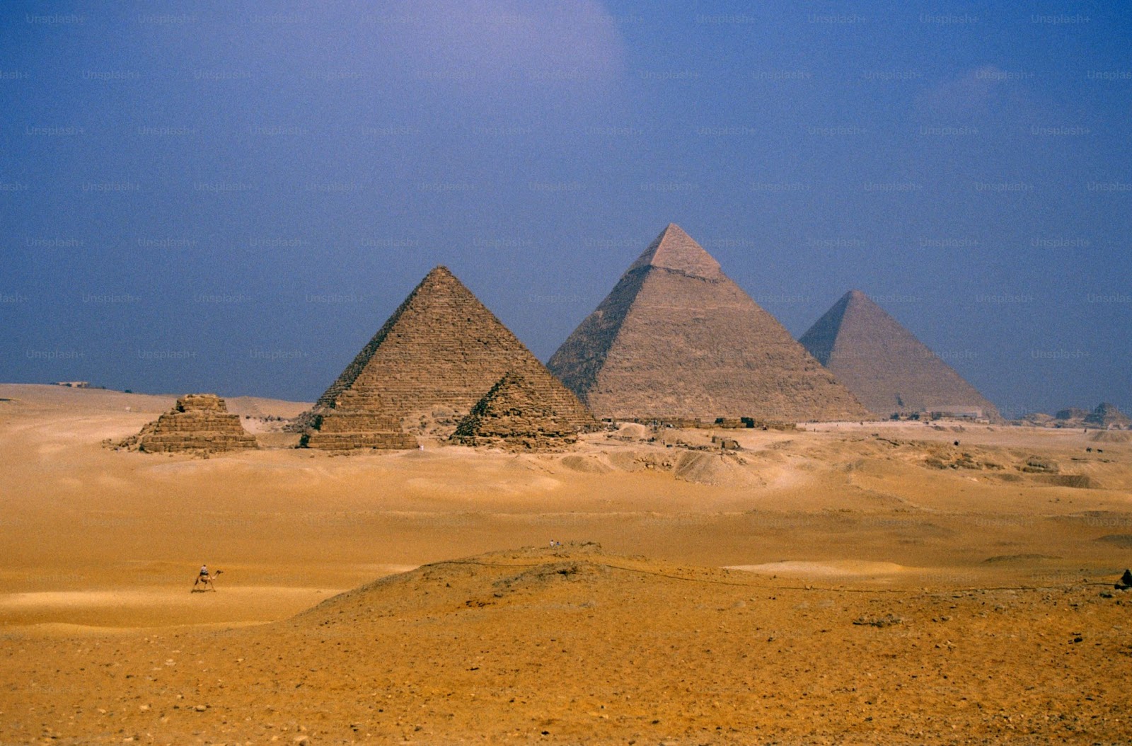 The ancient Pyramids of Giza are surrounded by golden desert in Egypt.