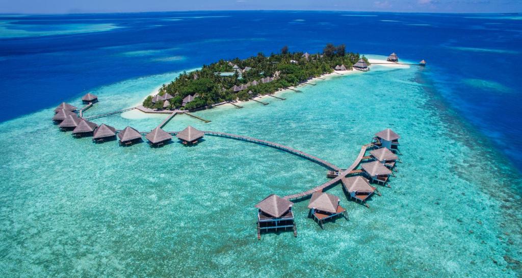 Overwater villas of Adaaran Club Rannalhi Maldives connected by wooden walkway above a lagoon.