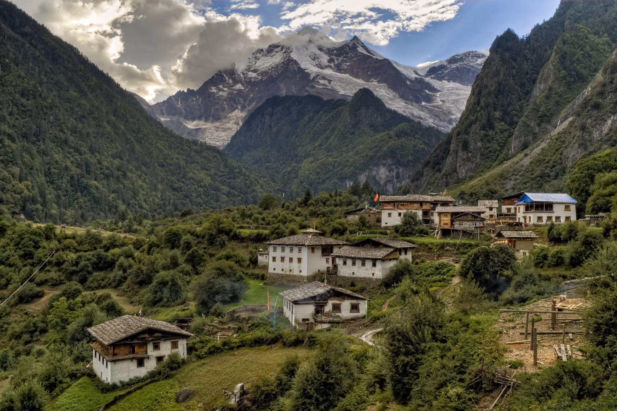  A traditional mountain village in Nepal with snow-capped peaks in the background.
