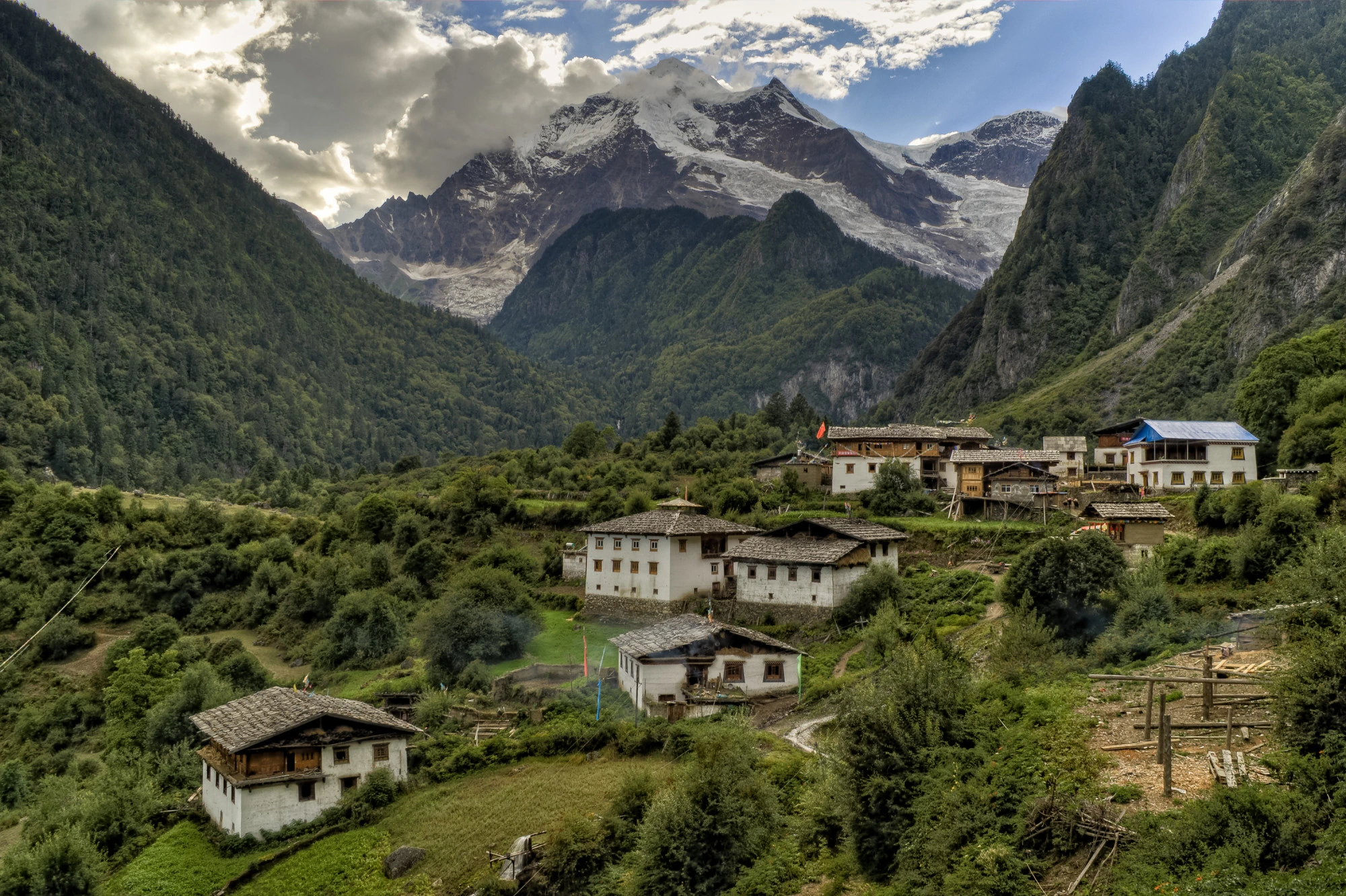  A traditional mountain village in Nepal with snow-capped peaks in the background.