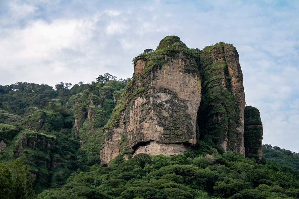 The ancient Sigiriya Rock Fortress rises surrounded by green forests in Sri Lanka.
