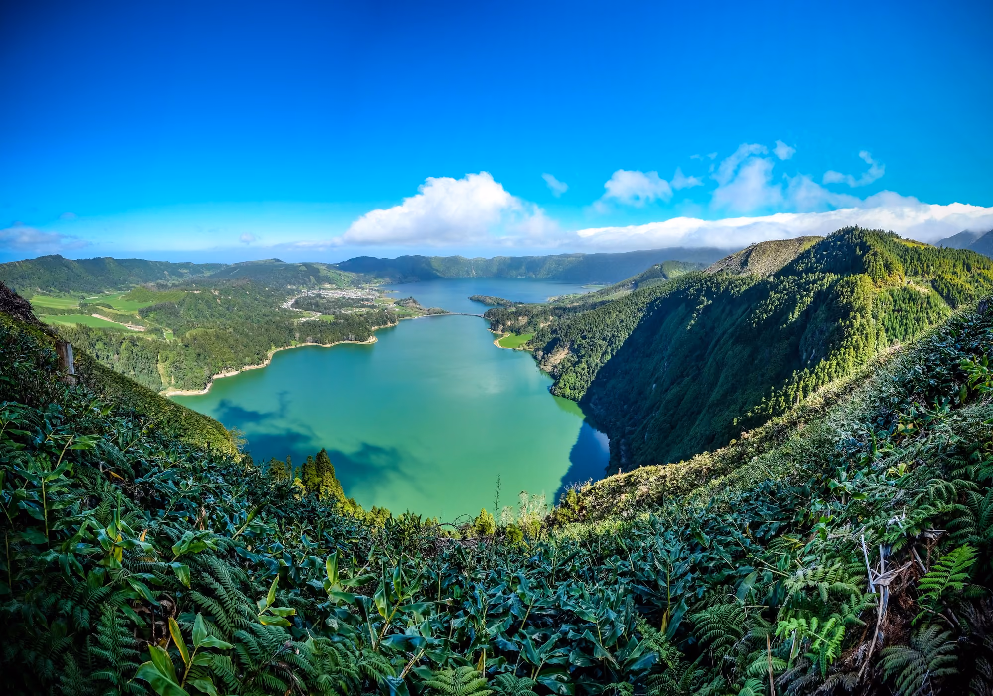View of Jamaica showing green mountains, blue waters, coral reefs, and small coastal settlements along the shoreline.