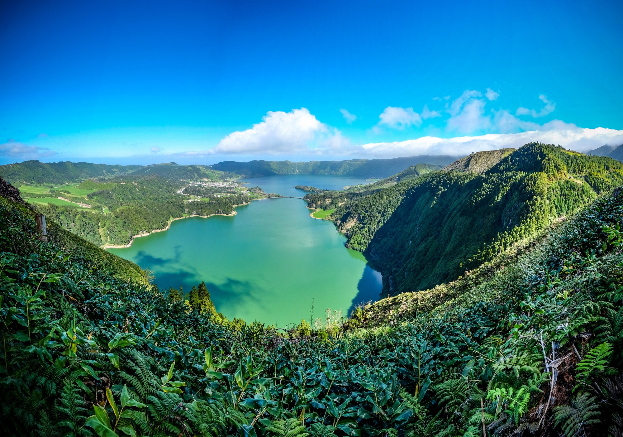  View of Jamaica showing green mountains, blue waters, coral reefs, and small coastal settlements along the shoreline.