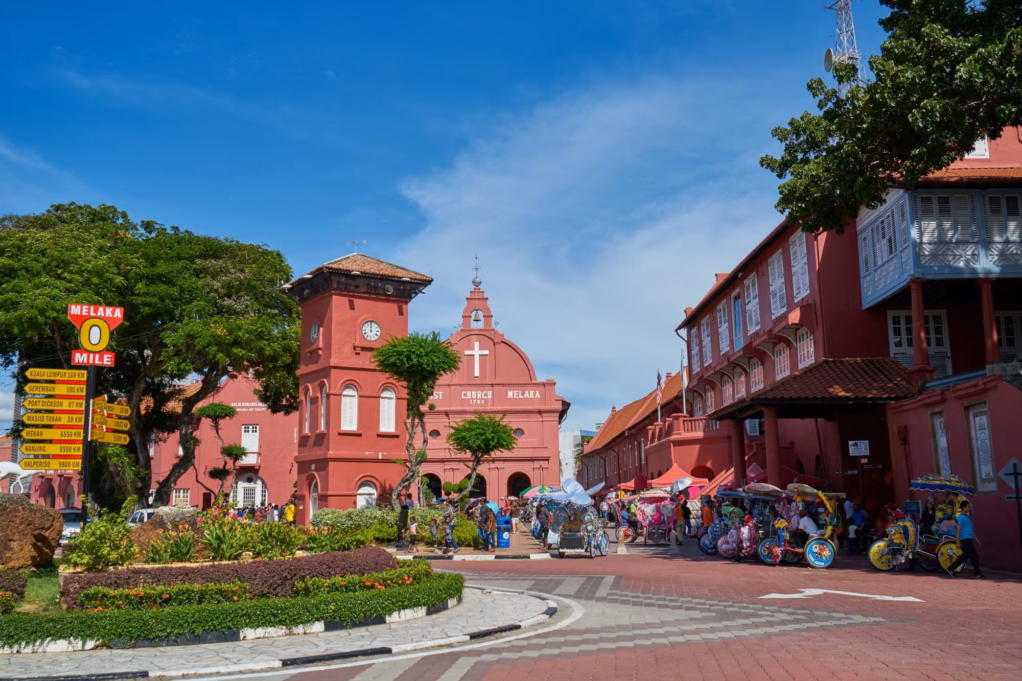 view of Bridgetown in Barbados, showing colorful buildings, palm trees, and bustling shops.