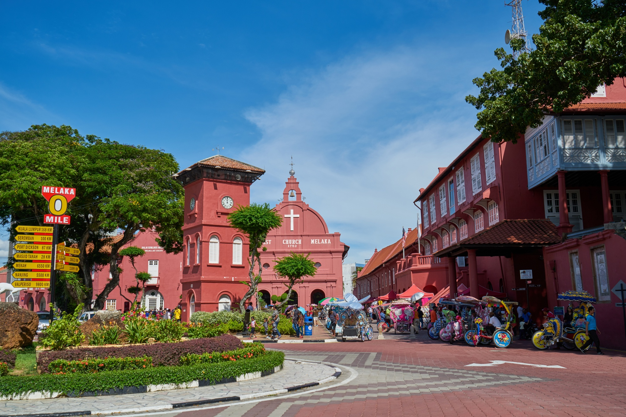 view of Bridgetown in Barbados, showing colorful buildings, palm trees, and bustling shops.