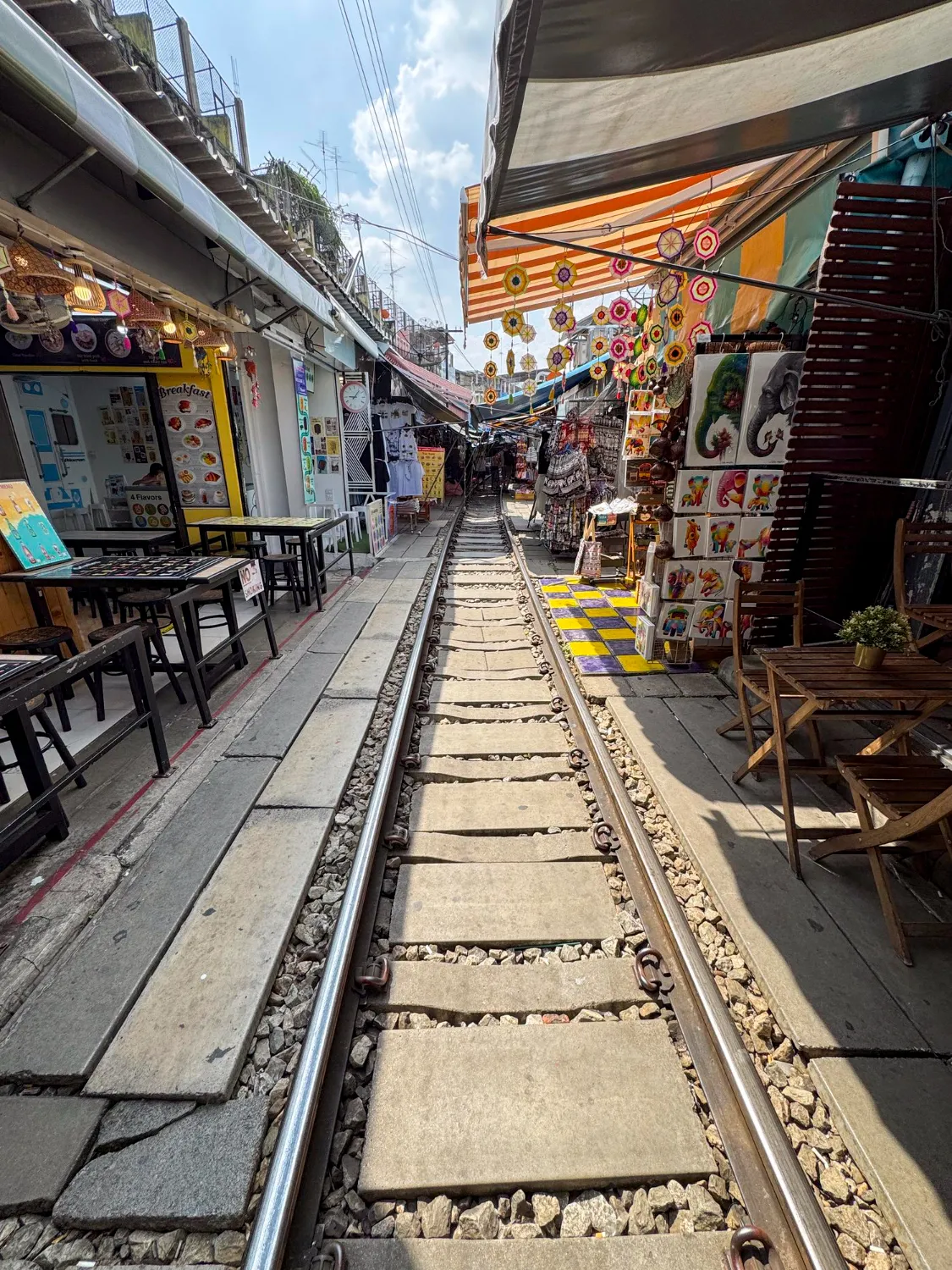 A red train passing through Hanoi’s famous Train Street, surrounded by narrow houses and cafes.