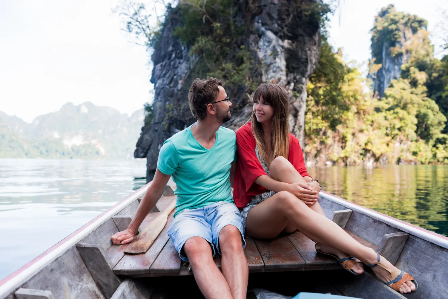 A couple enjoying boat ride on green waters