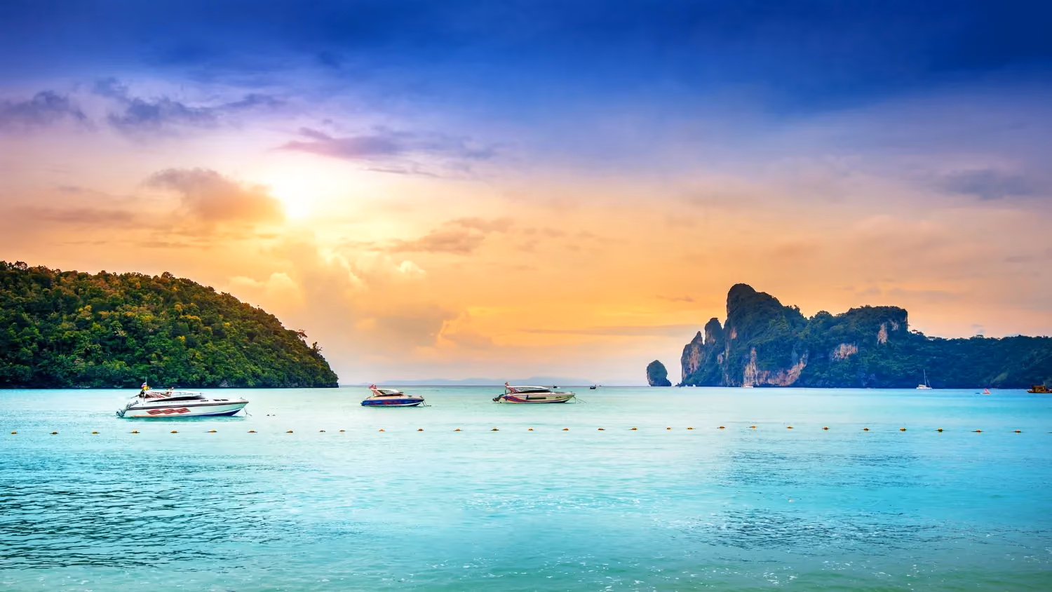 Koh Phi Phi Islands, Thailand, showing dramatic limestone cliffs, clear blue waters, and sandy beach.