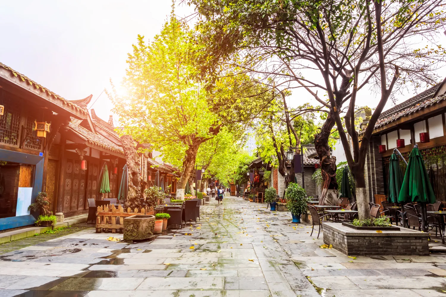  Bustling street view of Hanoi’s Old Quarter with narrow roads, colorful signs, street vendors, and rows of small red and green plastic chairs set up for local eateries.