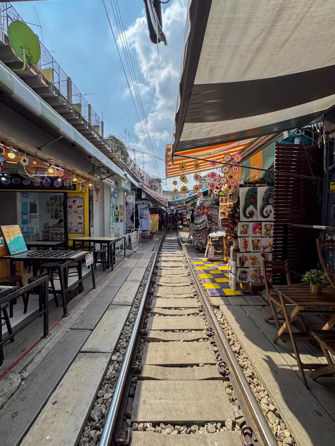  A red train passing through Hanoi’s famous Train Street, surrounded by narrow houses and cafes.
