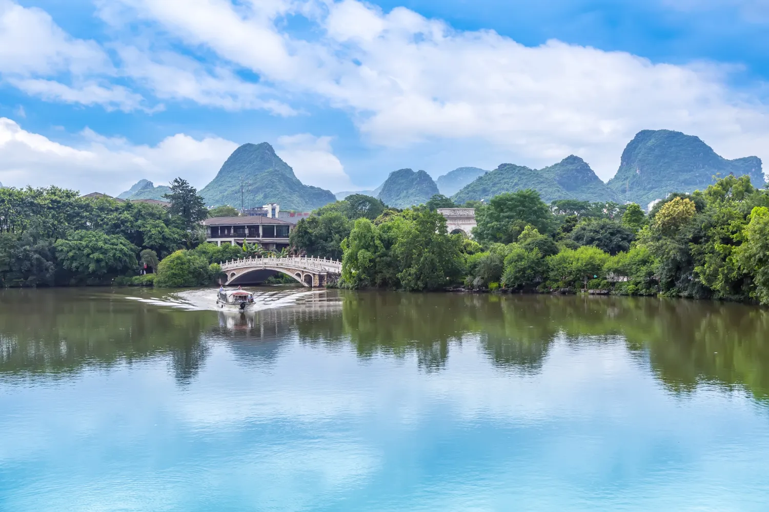 A village by the river with limestone mountains and reflections in Ninh Binh.