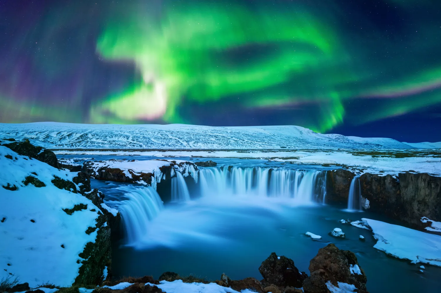  A stunning view of the Northern Lights illuminating the night sky above a mountain in Iceland