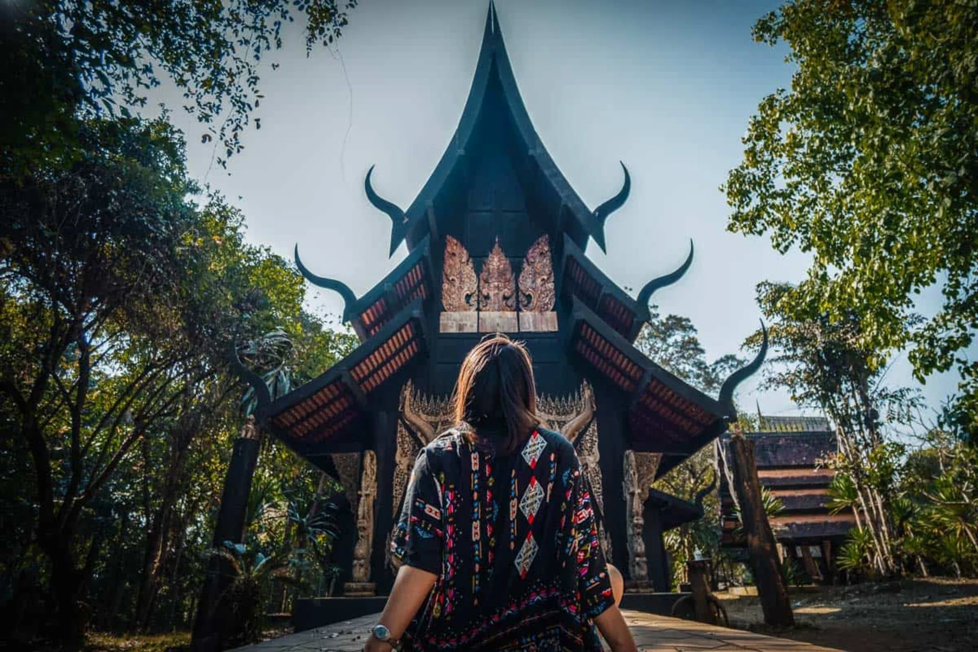 A collection of dark, artistic wooden structures showcasing bold Northern Thai craftsmanship.